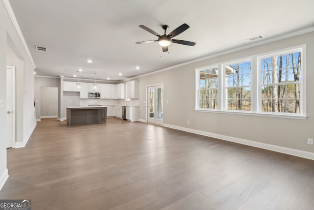 unfurnished living room with dark wood-style floors, crown molding, baseboards, and ceiling fan