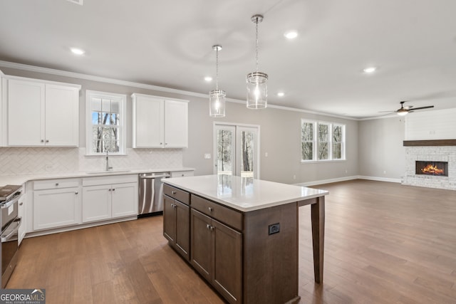 kitchen featuring crown molding, decorative backsplash, light countertops, and dishwasher