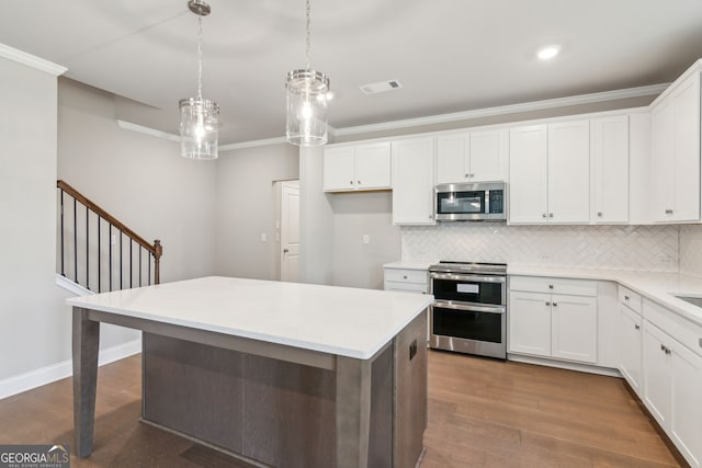 kitchen featuring ornamental molding, appliances with stainless steel finishes, dark wood finished floors, and tasteful backsplash