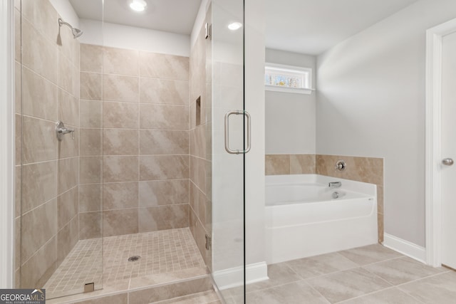 bathroom with tile patterned flooring, a shower stall, and a bath