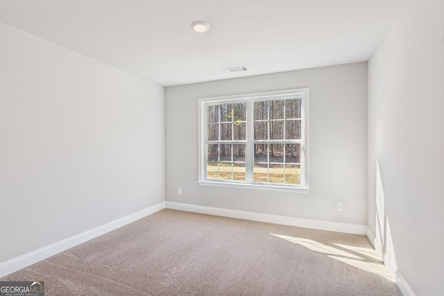 spare room featuring carpet flooring, visible vents, and baseboards