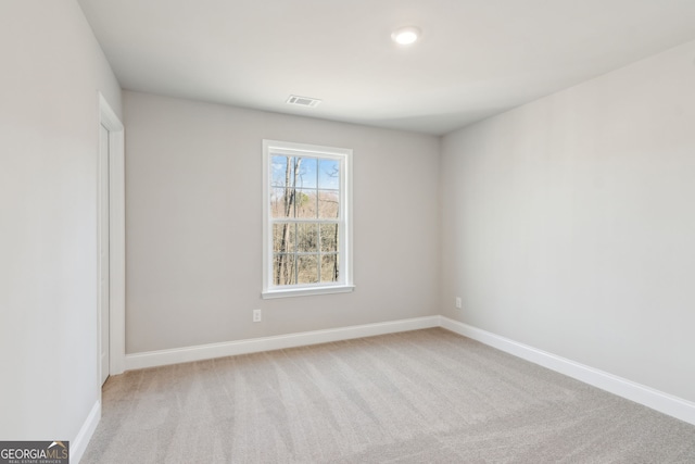 unfurnished room featuring visible vents, light carpet, and baseboards