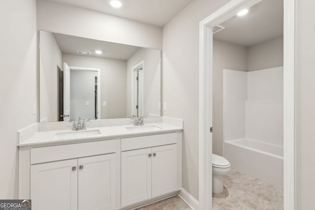 bathroom featuring visible vents, a sink, toilet, and double vanity