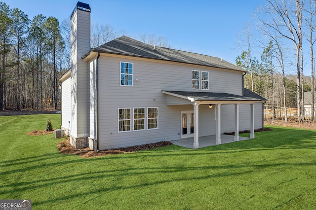 back of house with a patio area, a chimney, central AC unit, and a lawn