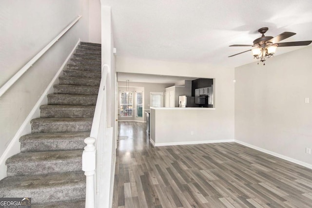 stairs featuring ceiling fan and wood-type flooring