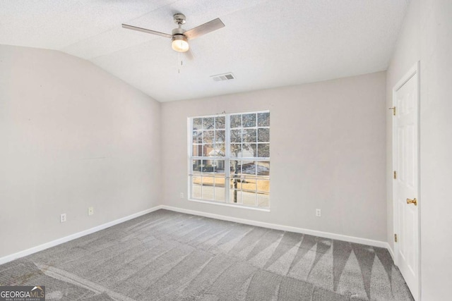 carpeted spare room featuring ceiling fan, a textured ceiling, and vaulted ceiling