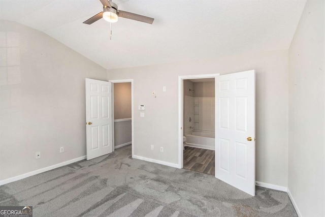 unfurnished bedroom with carpet flooring, ensuite bath, ceiling fan, and lofted ceiling