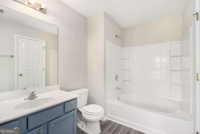 full bathroom with vanity,  shower combination, toilet, a textured ceiling, and wood-type flooring