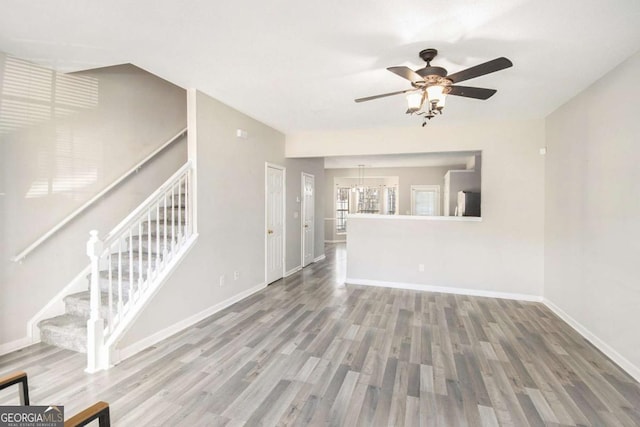 unfurnished living room featuring hardwood / wood-style flooring and ceiling fan