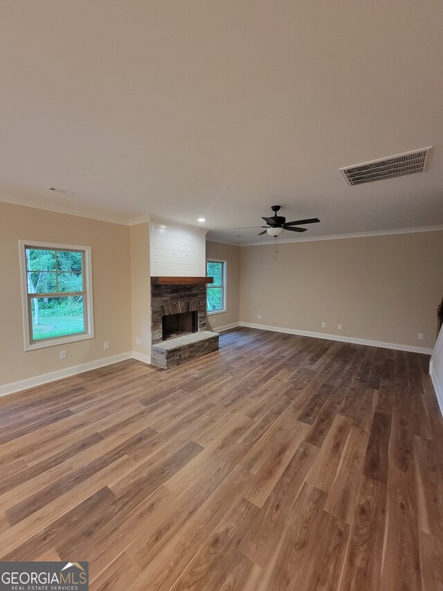 15 Dixon Rd, Newnan, GA 30263 - unfurnished living room with plenty of natural light, a stone fireplace, visible vents, baseboards, and ornamental molding