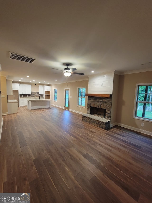 15 Dixon Rd, Newnan, GA 30263 - unfurnished living room with visible vents, ornamental molding, a fireplace, baseboards, and dark wood-type flooring