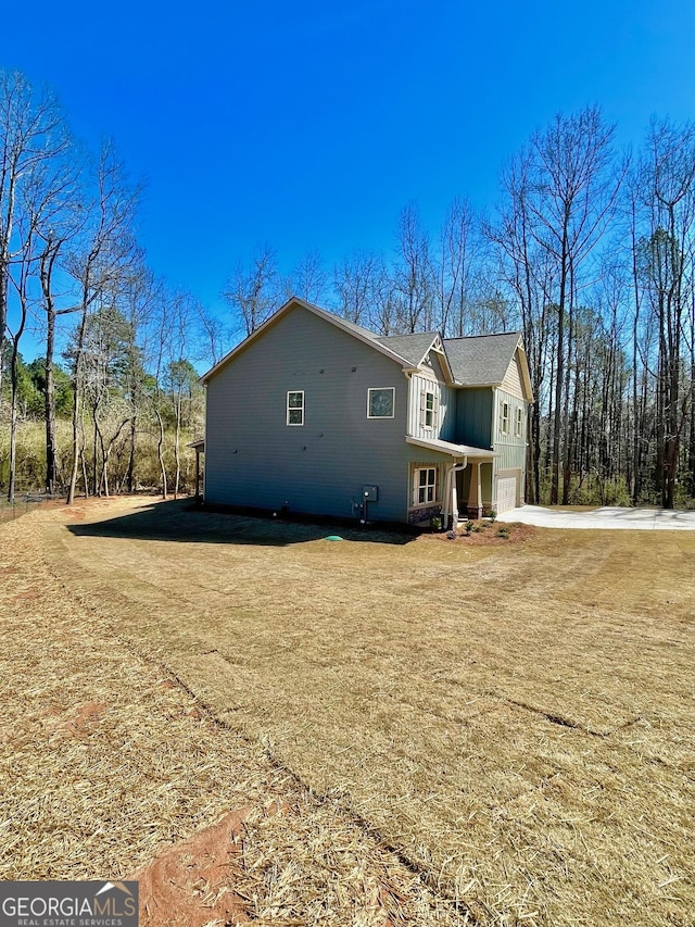 view of property exterior with concrete driveway, board and batten siding, and an attached garage