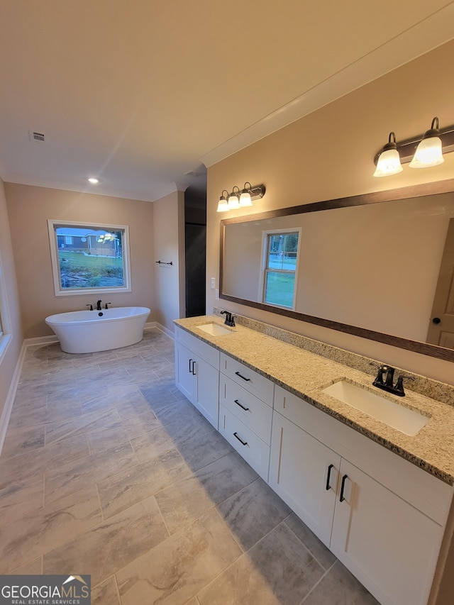 15 Dixon Rd, Newnan, GA 30263 - bathroom with double vanity, a freestanding tub, visible vents, and a sink
