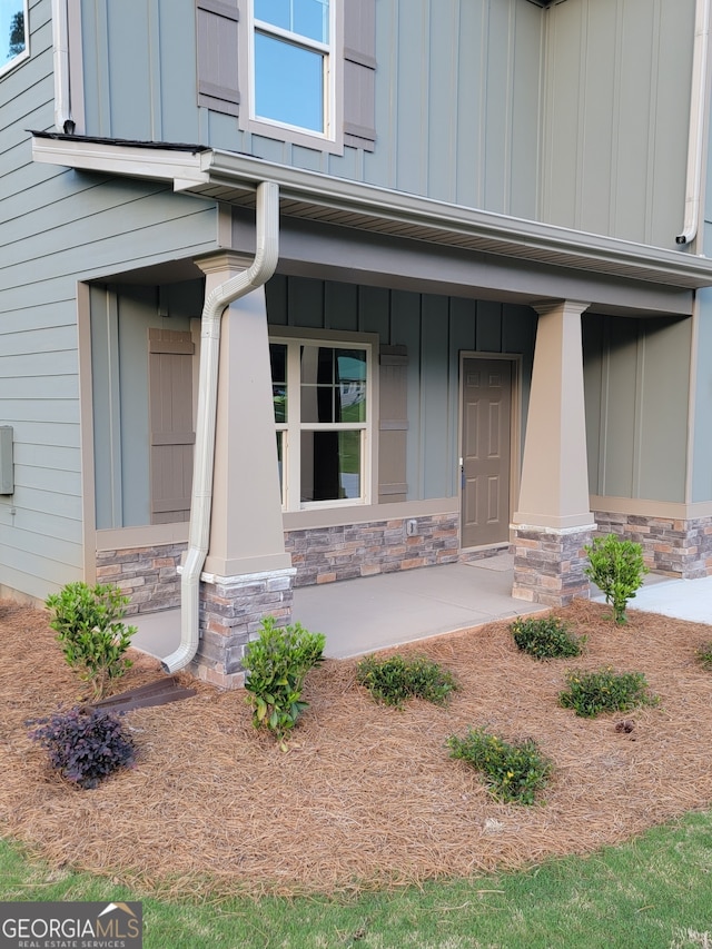 15 Dixon Rd, Newnan, GA 30263 - doorway to property featuring board and batten siding, stone siding, and a porch