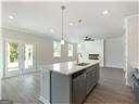 kitchen with decorative light fixtures, sink, a center island with sink, and gray cabinetry