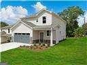 neoclassical home with a garage and a front yard