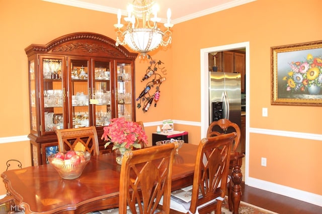 dining area featuring dark wood-type flooring, a notable chandelier, and ornamental molding