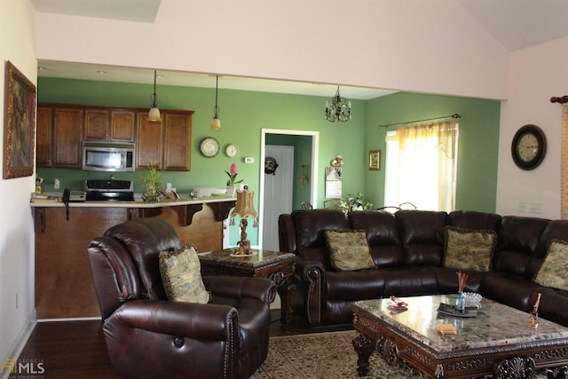 living room featuring vaulted ceiling, dark wood-type flooring, and a chandelier