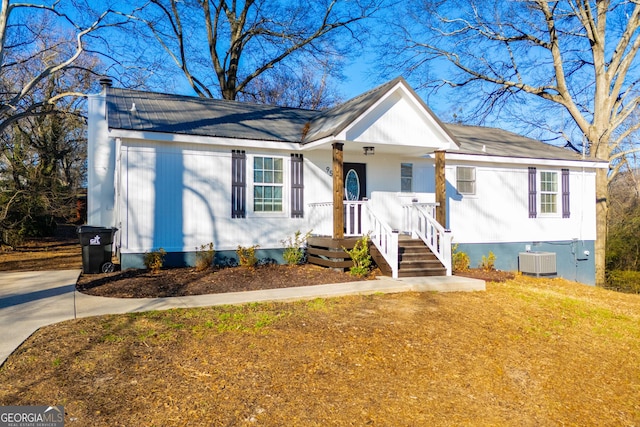 ranch-style home featuring cooling unit and a front lawn