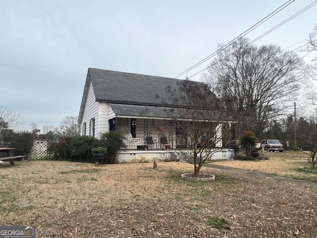 view of property exterior featuring a porch and a yard