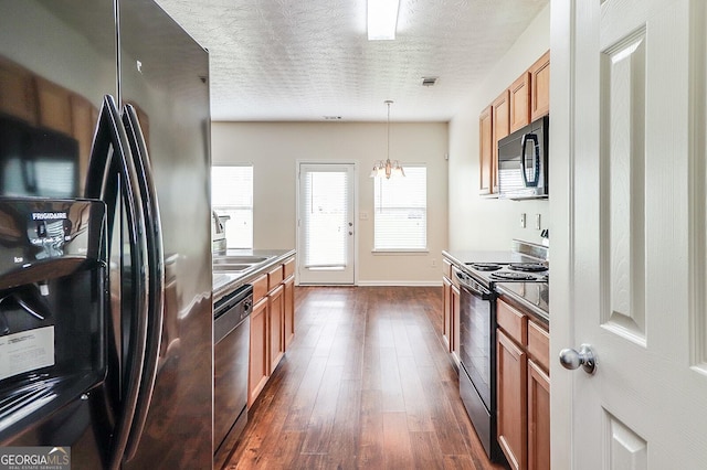 53 Providence Oak Ct, Lawrenceville, GA 30046 - kitchen with black appliances, dark wood finished floors, brown cabinets, hanging light fixtures, and a textured ceiling