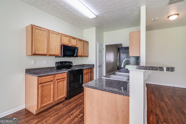 kitchen with black appliances, dark hardwood / wood-style floors, a textured ceiling, and kitchen peninsula