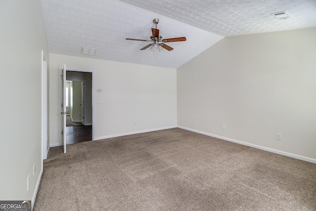 carpeted empty room featuring a textured ceiling, ceiling fan, and vaulted ceiling