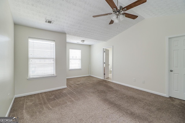 unfurnished room with carpet flooring, a textured ceiling, ceiling fan, and vaulted ceiling