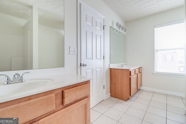 bathroom with a textured ceiling, tile patterned floors, and vanity