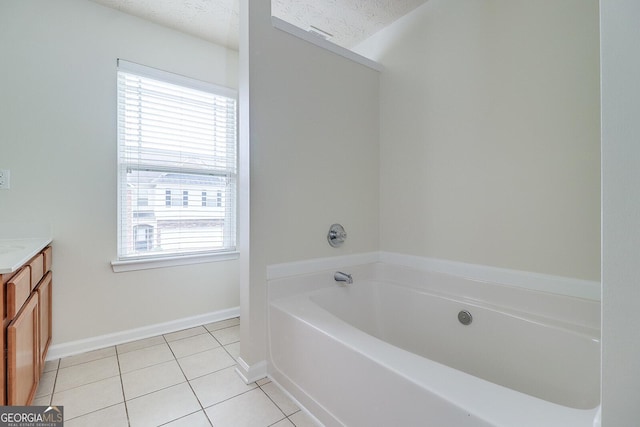 bathroom with tile patterned floors, vanity, a textured ceiling, and a bathtub