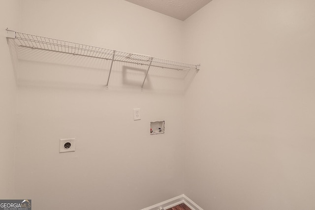 laundry area with a textured ceiling, hookup for an electric dryer, and hookup for a washing machine