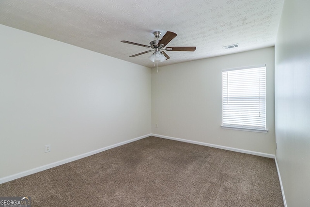 spare room with a textured ceiling, ceiling fan, and carpet