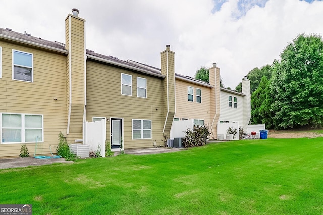 back of house with a yard and central AC