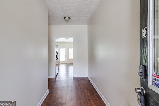 hallway featuring a textured ceiling and dark hardwood / wood-style flooring