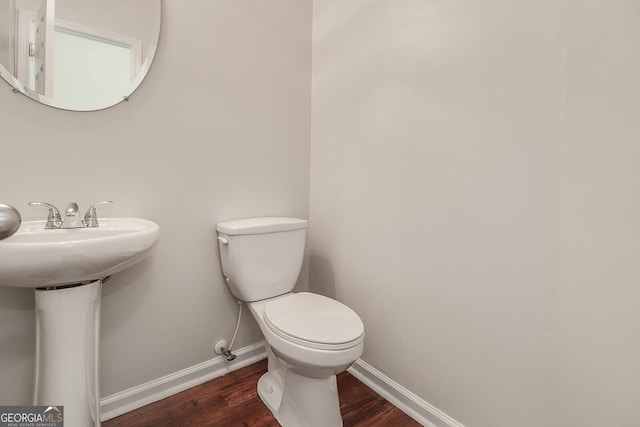 bathroom with toilet, wood-type flooring, and sink