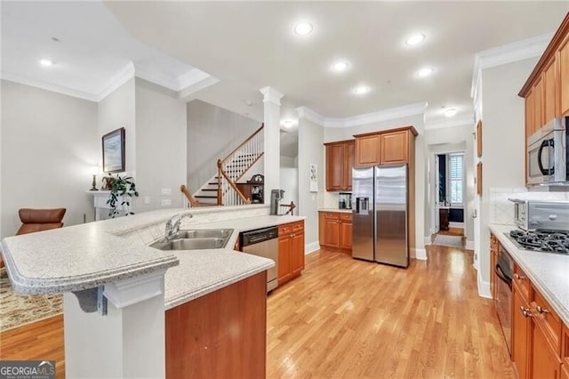 kitchen featuring a kitchen breakfast bar, sink, light hardwood / wood-style flooring, an island with sink, and stainless steel appliances