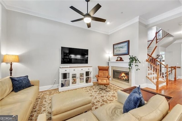 living room featuring hardwood / wood-style flooring, ceiling fan, and ornamental molding