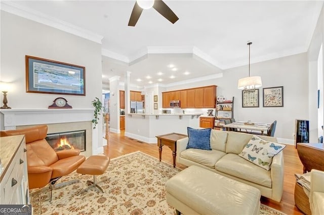 living room with ceiling fan, light hardwood / wood-style floors, and crown molding