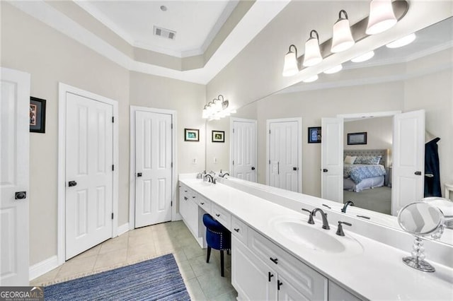 bathroom featuring tile patterned flooring, vanity, crown molding, and a tray ceiling