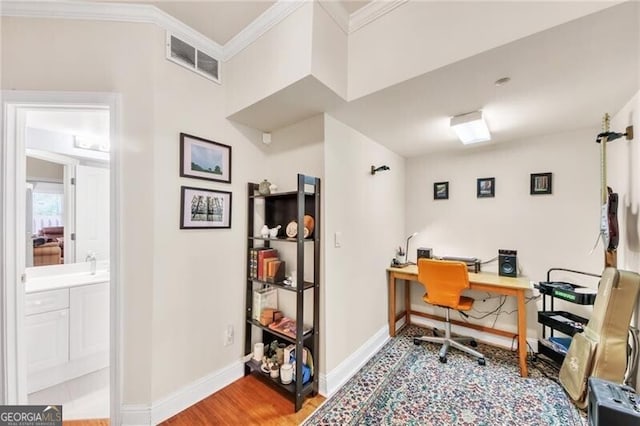 home office with hardwood / wood-style flooring and crown molding