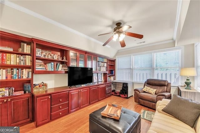 living room with light wood-type flooring, ceiling fan, and crown molding