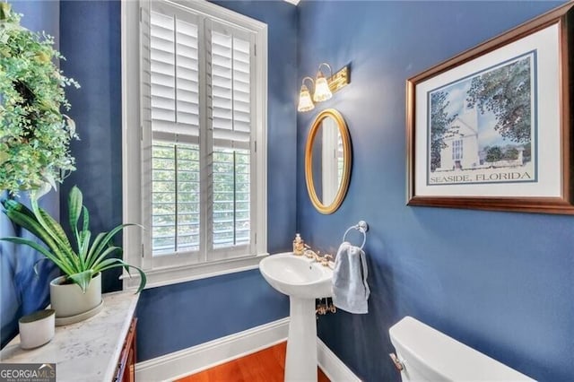 bathroom featuring wood-type flooring and toilet