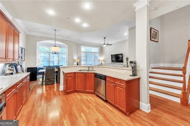 kitchen with kitchen peninsula, pendant lighting, ceiling fan with notable chandelier, and sink