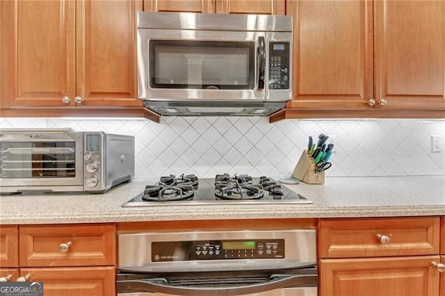 kitchen with appliances with stainless steel finishes and backsplash