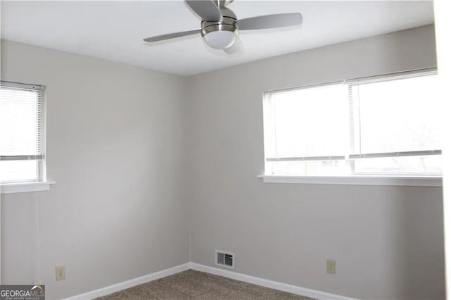 carpeted empty room featuring plenty of natural light and ceiling fan