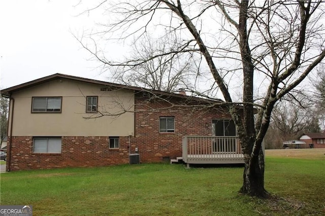 rear view of property with a deck, central AC unit, and a lawn