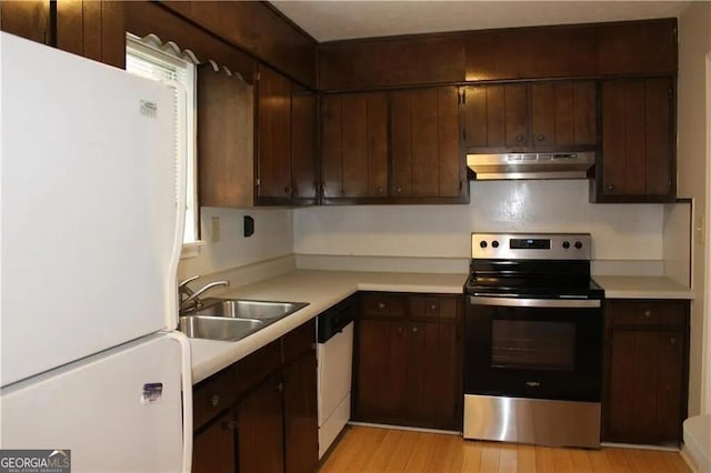 kitchen featuring white appliances, dark brown cabinetry, and sink