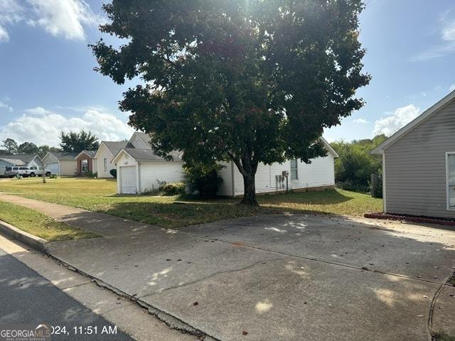 view of side of property featuring a lawn and a garage