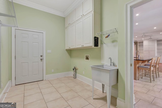 laundry area with ceiling fan, cabinets, hookup for a washing machine, light tile patterned flooring, and ornamental molding