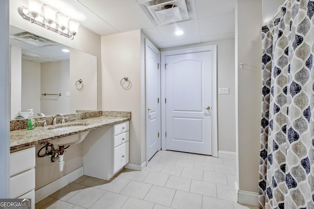 bathroom with tile patterned floors, walk in shower, and sink